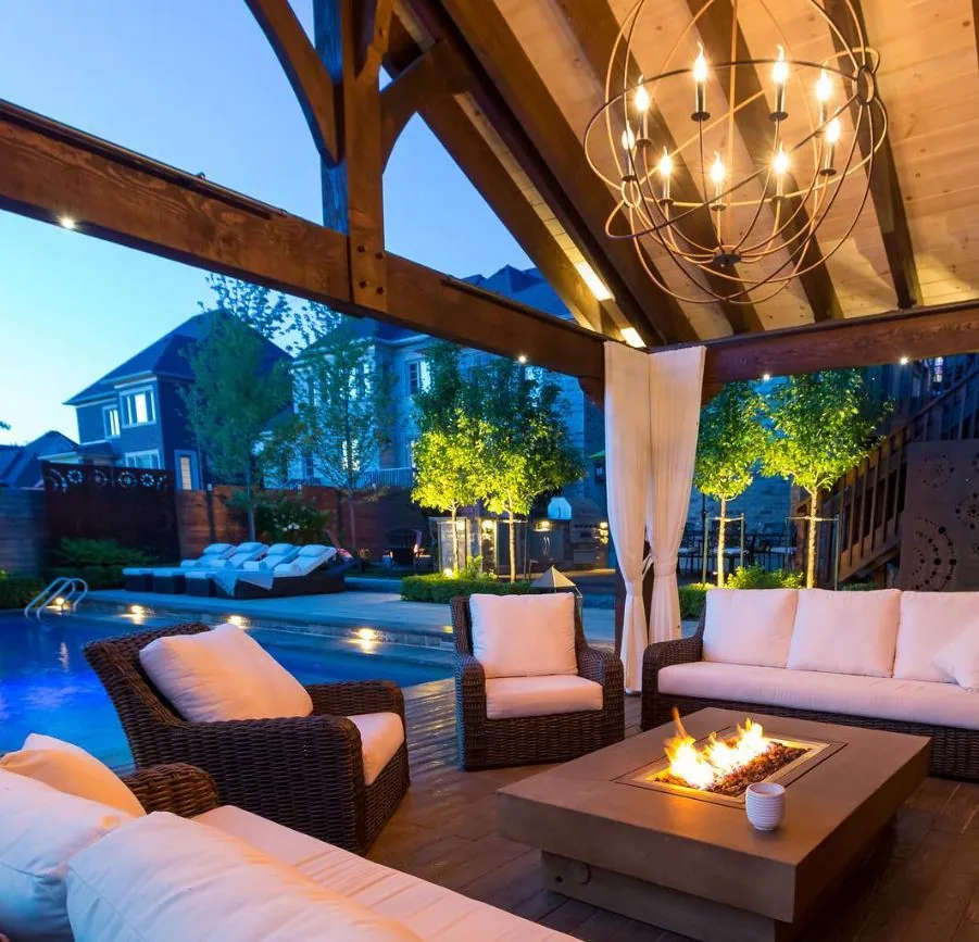 Covered outdoor lounge beside a lit pool