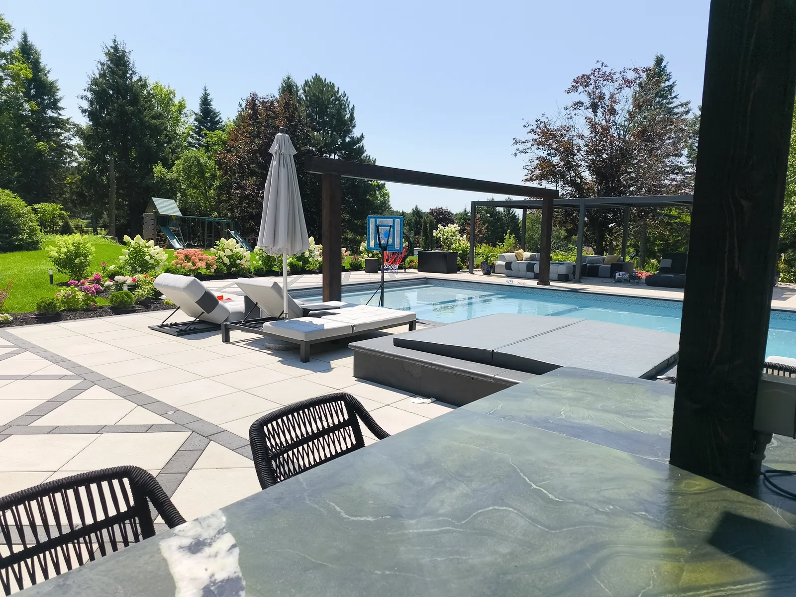 Pool and pergola with loungers in late afternoon light