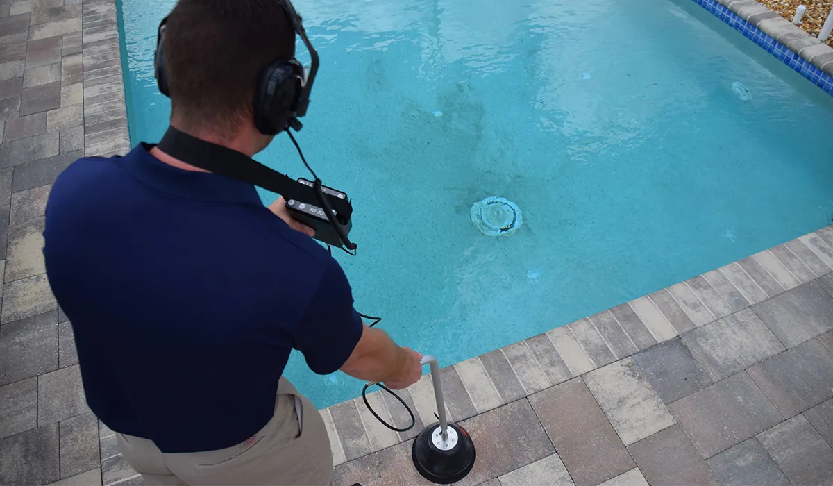 Pool Tec technician listening for a leak with acoustic equipment