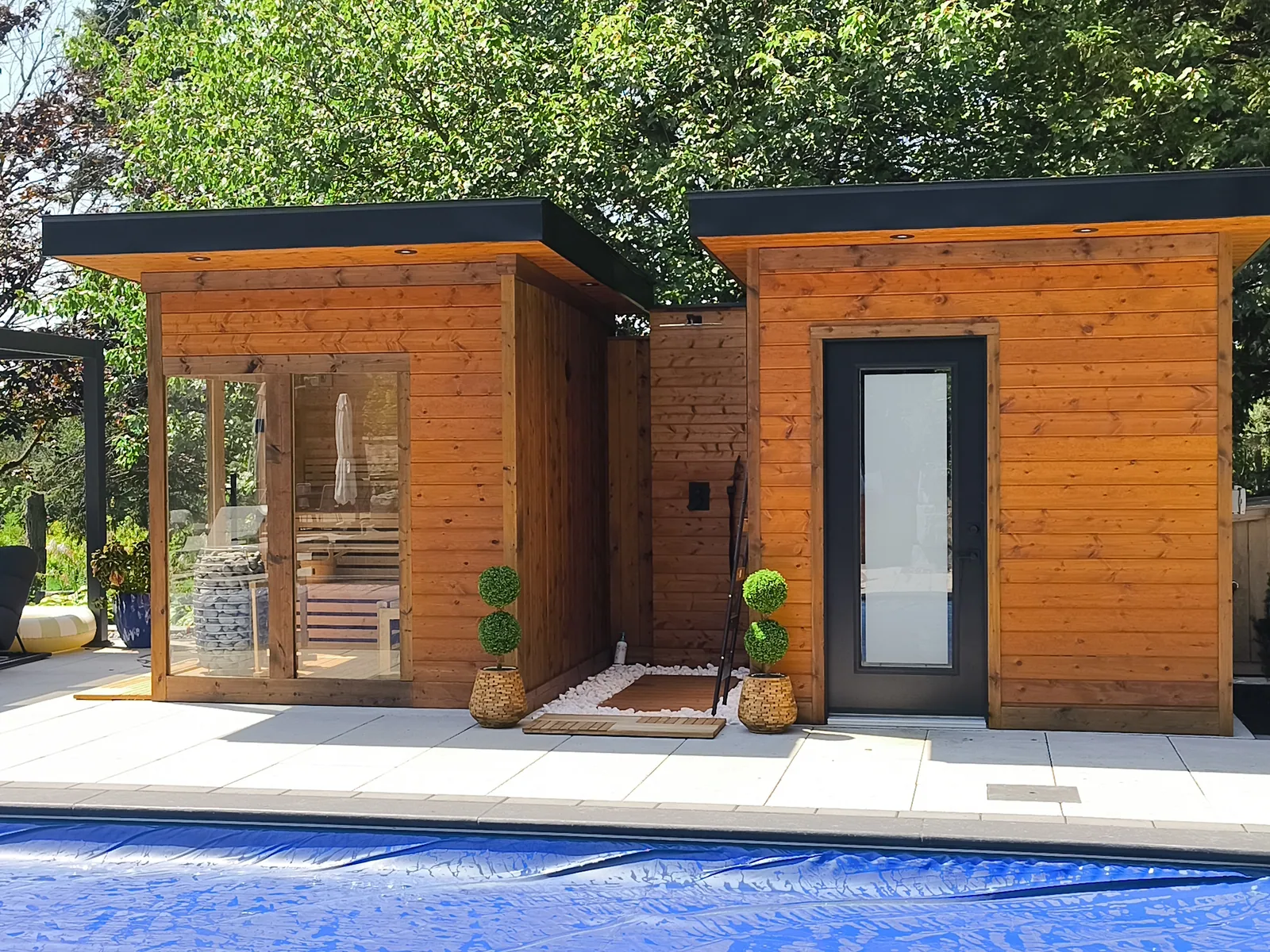 Cedar sauna and washroom building beside a covered pool