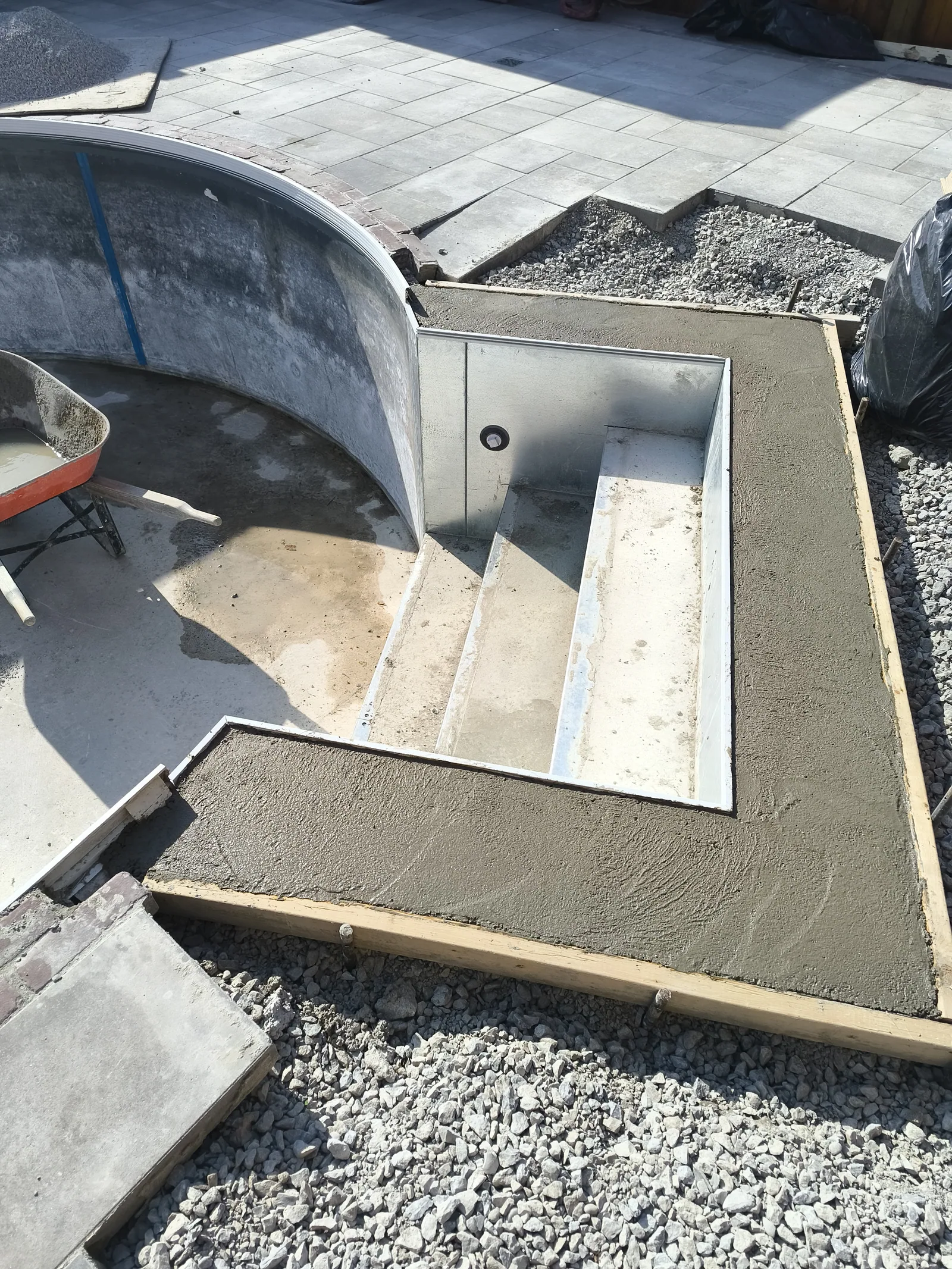 New concrete steps and bench formed during a pool renovation